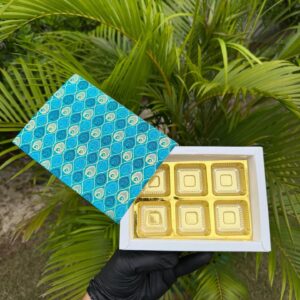 6-Piece Chocolate Box with Turquoise Peacock Feather Sleeve & Golden Cavity Tray   Color: Turquoise & Aqua Blue Peacock Feather Motif with Metallic Gold Inner Tray