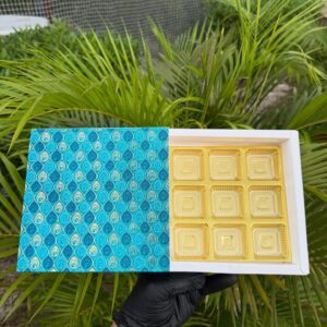 9-Piece Chocolate Box with Turquoise Peacock Feather Sleeve & Golden Cavity Tray   Color: Turquoise & Aqua Blue Peacock Feather Motif with Metallic Gold Inner Tray