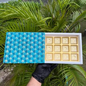 12-Piece Chocolate Box with Turquoise Peacock Feather Sleeve & Golden Cavity Tray   Color: Turquoise & Aqua Blue Peacock Feather Motif with Metallic Gold Inner Tray